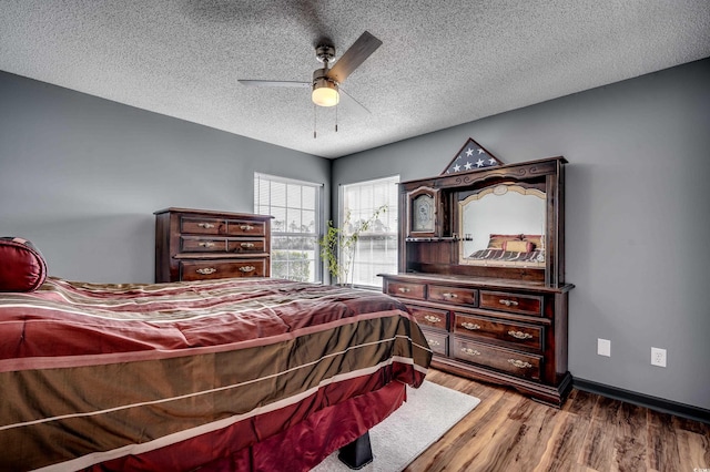 bedroom featuring ceiling fan, wood-type flooring, and a textured ceiling