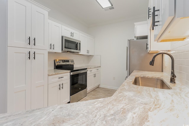 130 Lazy Willow Ln Unit 204, Myrtle Beach, SC 29588 - kitchen with light stone counters, stainless steel appliances, a sink, crown molding, and tasteful backsplash
