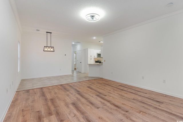 unfurnished living room featuring light wood-style flooring, visible vents, baseboards, and ornamental molding