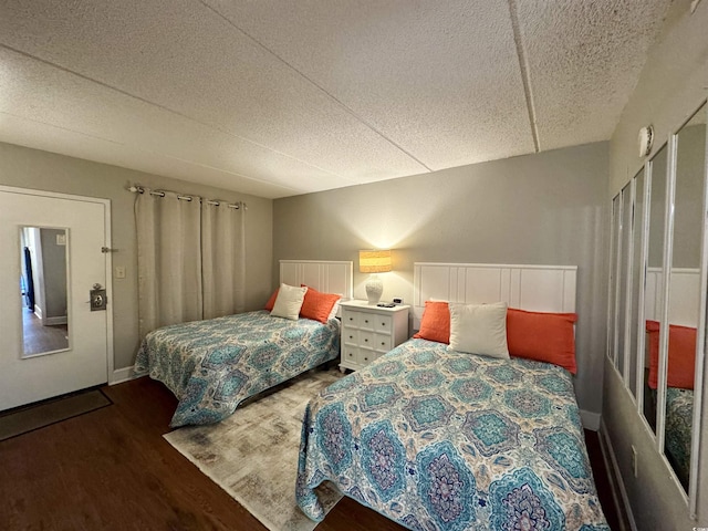 bedroom with dark wood-type flooring and a textured ceiling