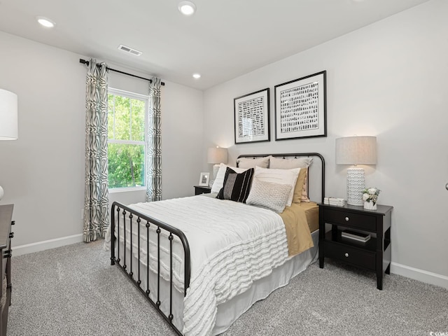 carpeted bedroom featuring recessed lighting, visible vents, and baseboards