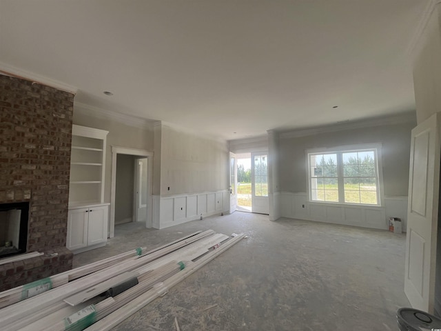 unfurnished living room with a wainscoted wall, a fireplace, a decorative wall, and crown molding