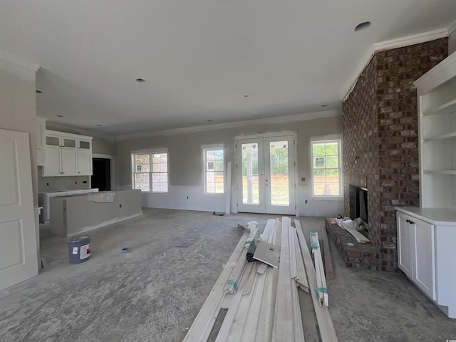 unfurnished living room featuring crown molding, french doors, and a fireplace