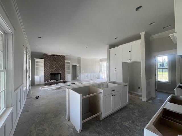 kitchen featuring white cabinetry, a center island, and ornamental molding