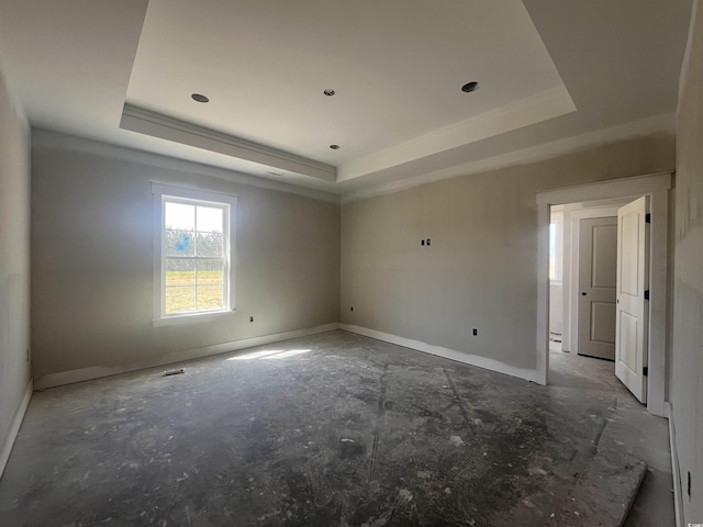 empty room with baseboards and a raised ceiling