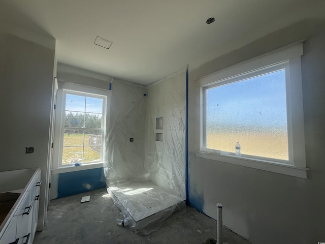 bathroom featuring vanity and a marble finish shower