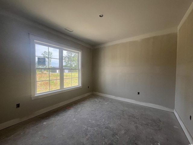 spare room with concrete floors and baseboards
