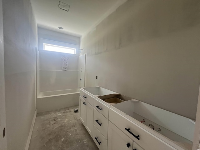 full bathroom featuring a bath, baseboards, and concrete flooring