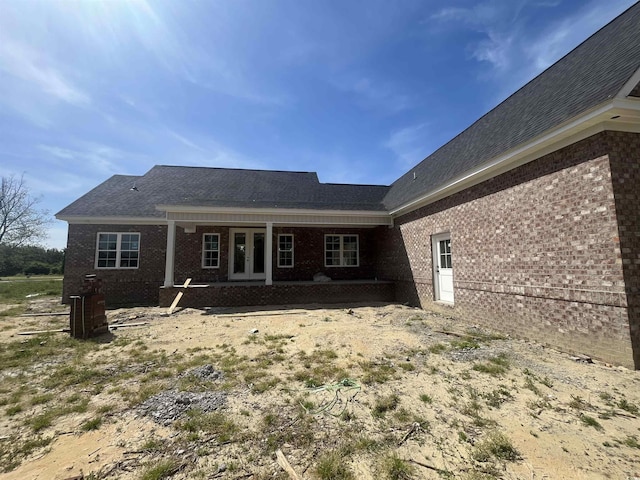 rear view of house with brick siding and french doors