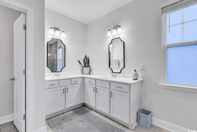 bathroom with vanity, a shower with door, and a wealth of natural light