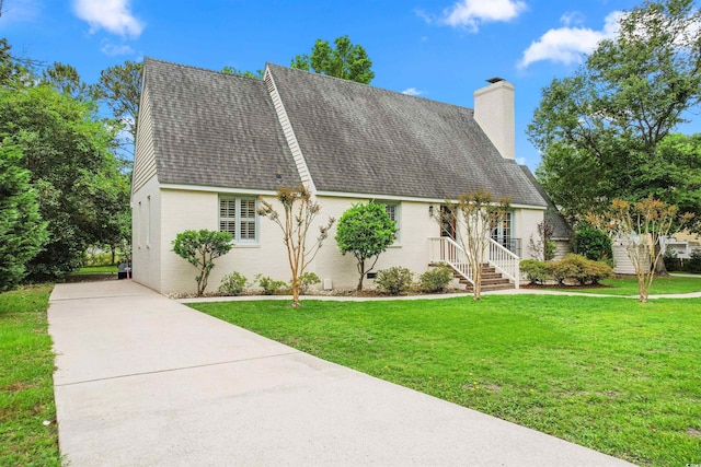 view of front of home with brick siding, roof with shingles, a chimney, a front yard, and crawl space