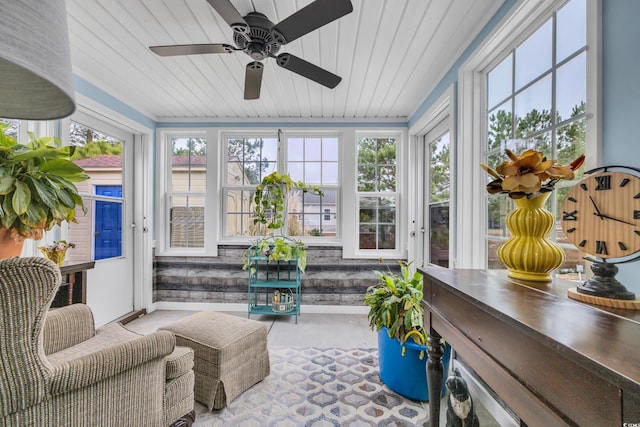 sunroom / solarium featuring ceiling fan, plenty of natural light, and wood ceiling