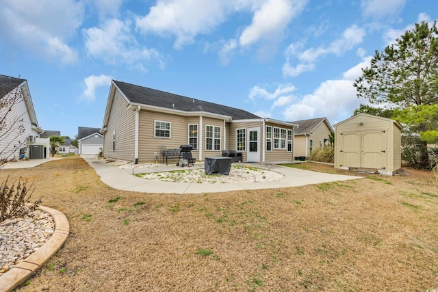 back of property featuring a storage shed, a lawn, an outdoor structure, central air condition unit, and a patio area