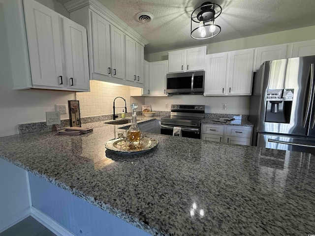 3700 Golf Colony Dr Unit 26G, Little River, SC 29566 - kitchen featuring stainless steel appliances, a sink, dark stone counters, white cabinets, and a textured ceiling