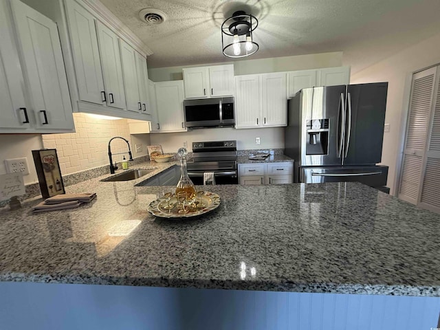 3700 Golf Colony Dr Unit 26G, Little River, SC 29566 - kitchen with stainless steel appliances, a sink, dark stone counters, and a textured ceiling