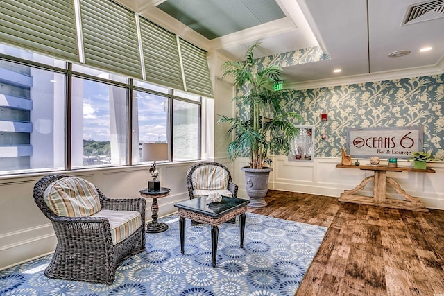 sitting room with hardwood / wood-style floors and ornamental molding