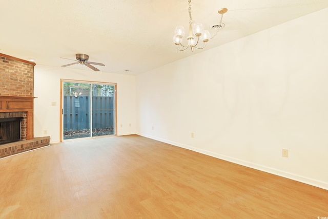 unfurnished living room with hardwood / wood-style flooring, a fireplace, and ceiling fan with notable chandelier