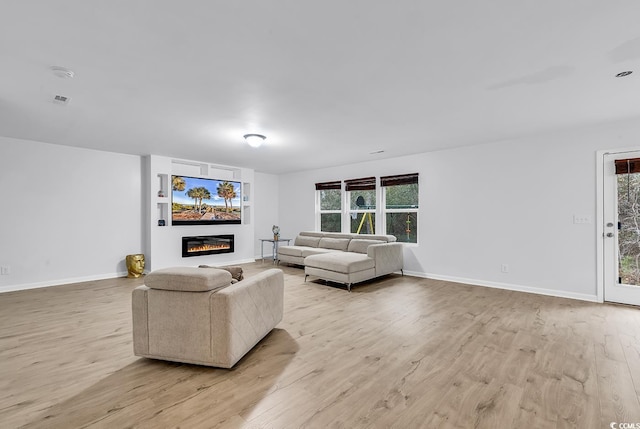 145 Bendick Ct, Little River, SC 29566 - living area with a glass covered fireplace, light wood-style flooring, baseboards, and visible vents