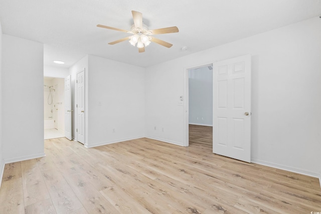 spare room featuring light wood-type flooring, ceiling fan, and baseboards