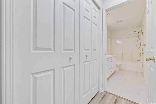 bathroom featuring visible vents, toilet, vanity, shower / bathtub combination, and a closet