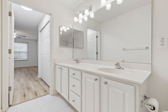 bathroom with double vanity, a ceiling fan, a sink, and tile patterned floors