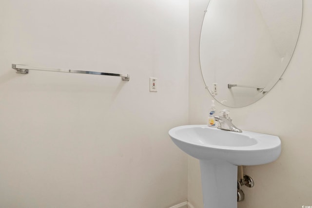 bathroom featuring baseboards and a sink