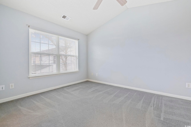 spare room with carpet, visible vents, vaulted ceiling, and baseboards