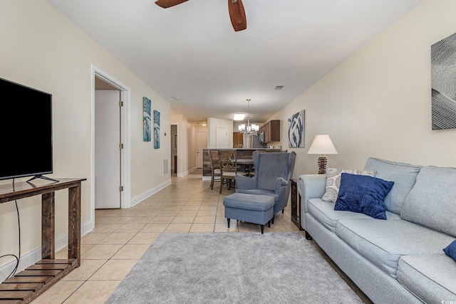 living room with light tile patterned flooring and ceiling fan with notable chandelier