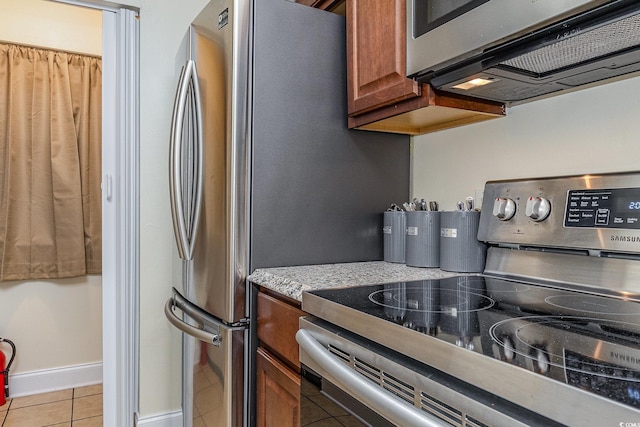 kitchen with light tile patterned floors and appliances with stainless steel finishes