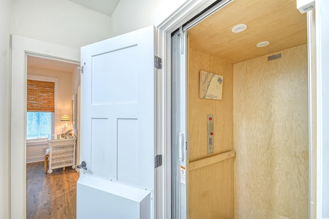 bathroom featuring elevator and hardwood / wood-style floors