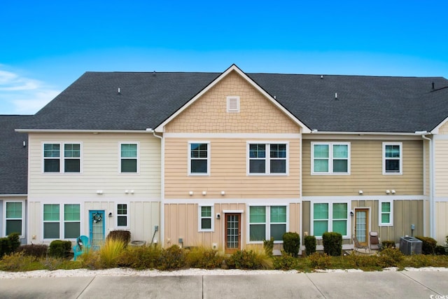 view of front of house with a shingled roof, cooling unit, and board and batten siding