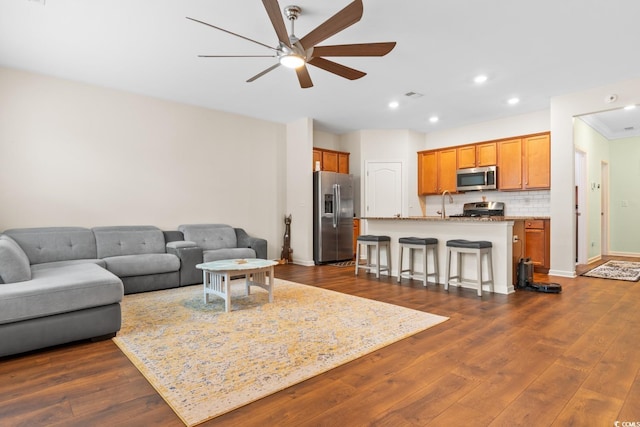 living room with dark wood-style floors, recessed lighting, visible vents, a ceiling fan, and baseboards