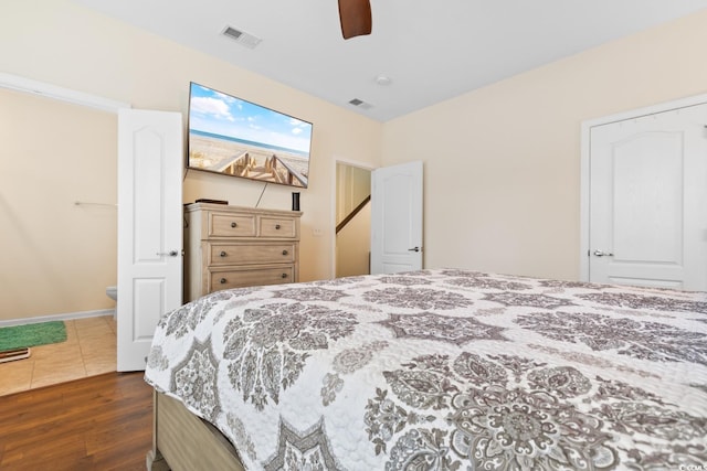 bedroom with ceiling fan, dark wood-type flooring, visible vents, and ensuite bathroom