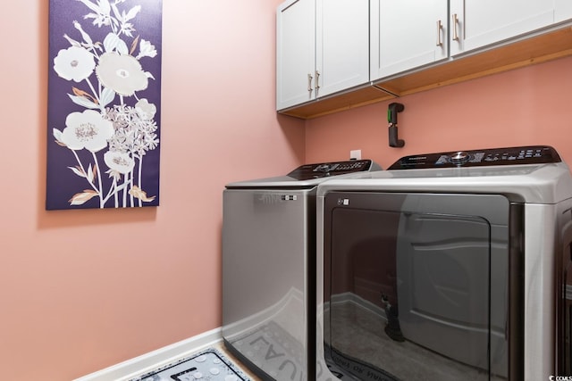 laundry area with cabinet space, independent washer and dryer, and baseboards