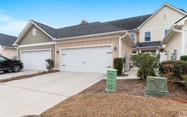 townhome / multi-family property featuring driveway, board and batten siding, an attached garage, and roof with shingles