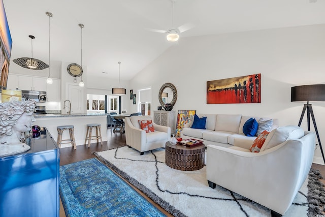 living room with dark wood-type flooring, high vaulted ceiling, and ceiling fan