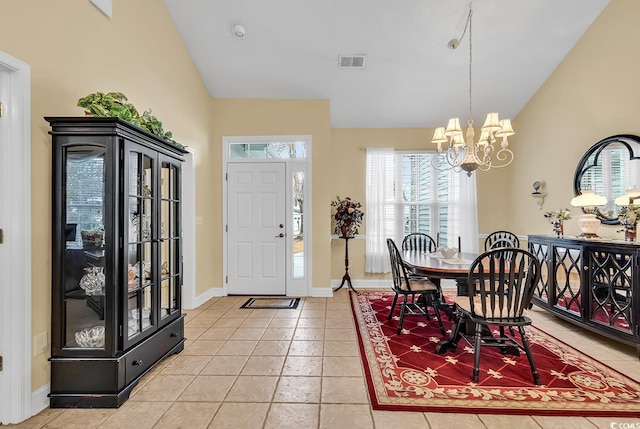 dining room featuring light tile patterned floors, a notable chandelier, and high vaulted ceiling