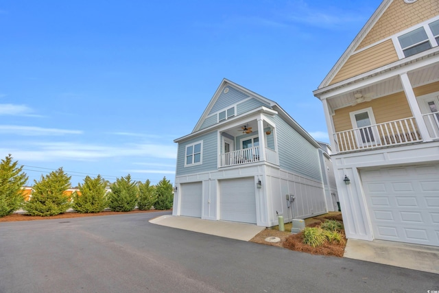 view of side of home featuring a garage, a balcony, and ceiling fan