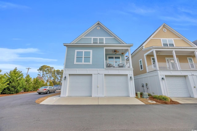 view of front of house featuring a garage, a balcony, and ceiling fan