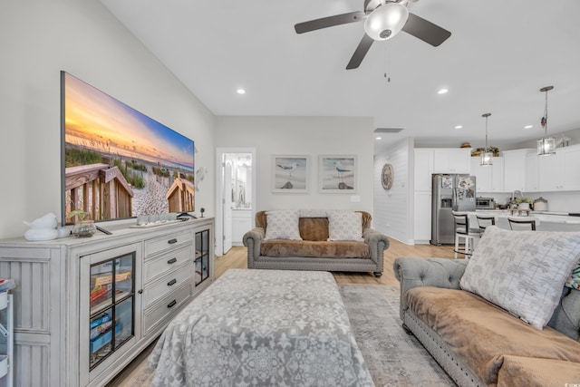 living room with ceiling fan and light wood-type flooring