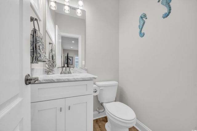 bathroom with vanity, wood-type flooring, and toilet