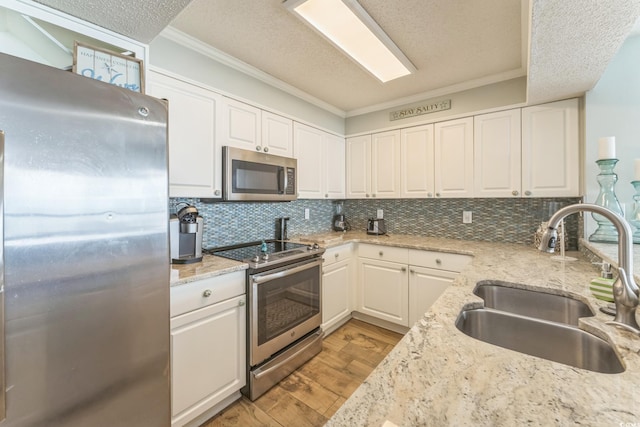 kitchen with a sink, light wood-style floors, appliances with stainless steel finishes, and white cabinets