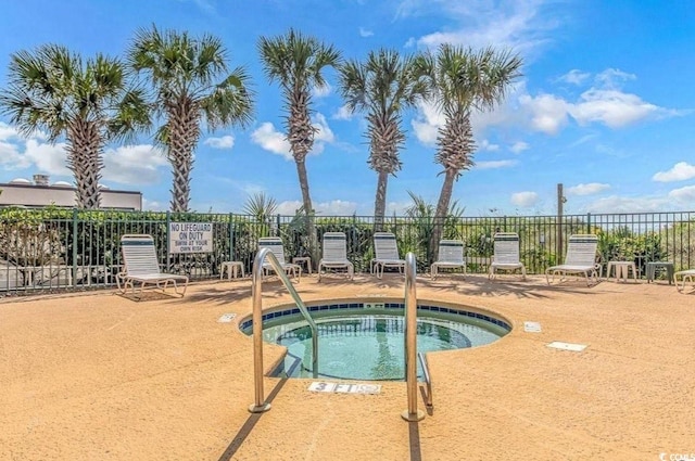 view of swimming pool featuring a patio, a community hot tub, and fence