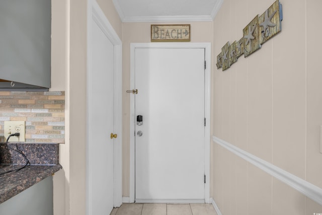 doorway to outside with ornamental molding and light tile patterned floors