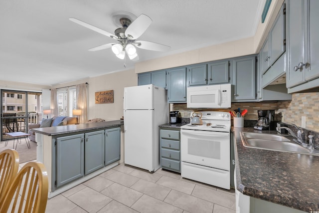 kitchen featuring a peninsula, white appliances, a sink, and tasteful backsplash