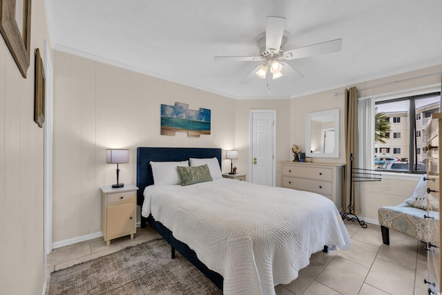 bedroom with ceiling fan, baseboards, ornamental molding, and light tile patterned floors