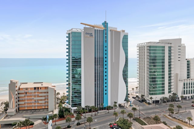 view of building exterior featuring a water view and a view of the beach