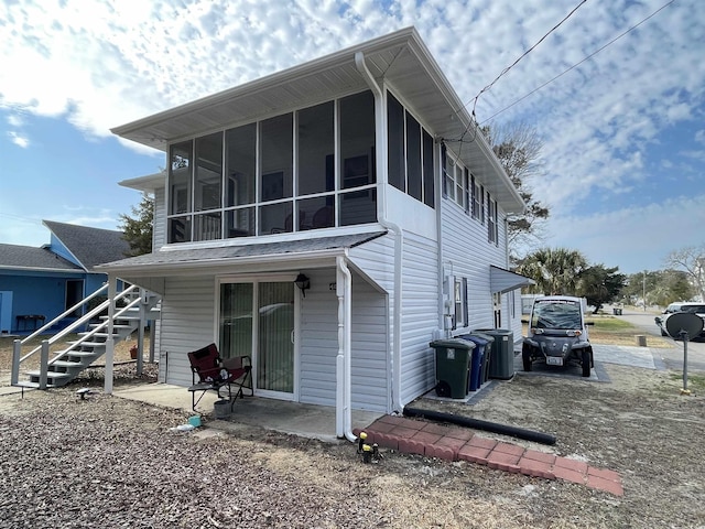 back of property with a sunroom and a patio