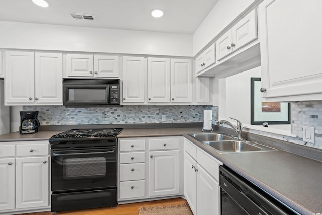 kitchen with sink, black appliances, white cabinets, light hardwood / wood-style floors, and backsplash