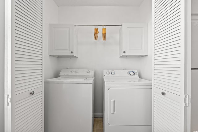 laundry area featuring washer and dryer and cabinets